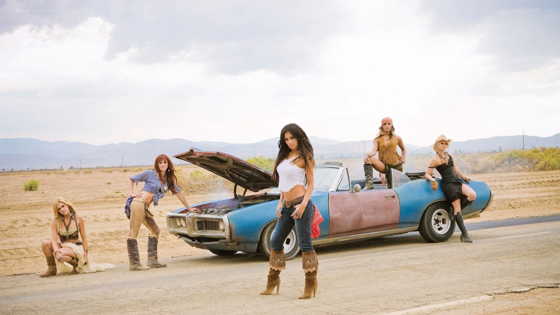 women with classic car in desert
