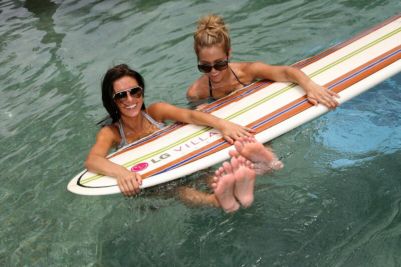 Women with surfboard in pool