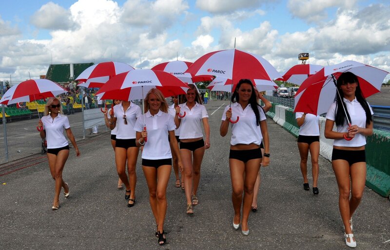 Women with umbrellas at race track