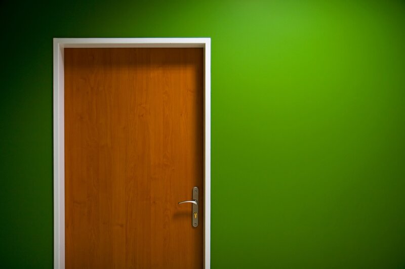 wood door on green wall