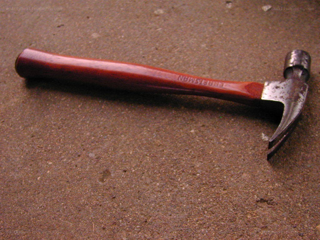 wood-handled hammer on ground