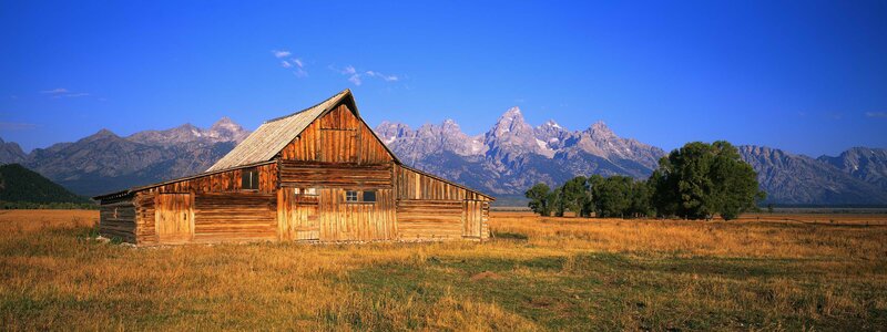 Wooden Barn in Field — Blue, Serene, Afternoon, Photograph, Mountains, Trees, Brown, Green
