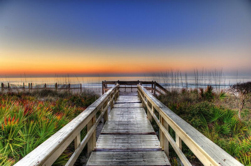 Wooden boardwalk to the beach at sunset