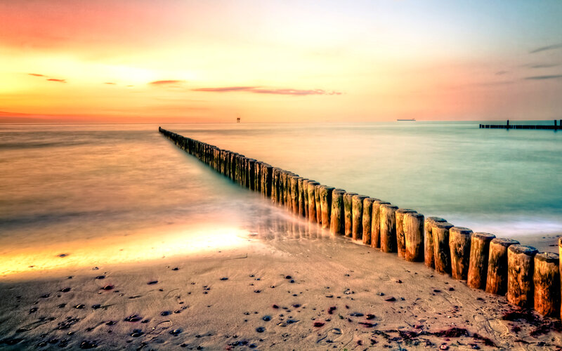 Wooden Breakwater at Sunset — Orange, Serene