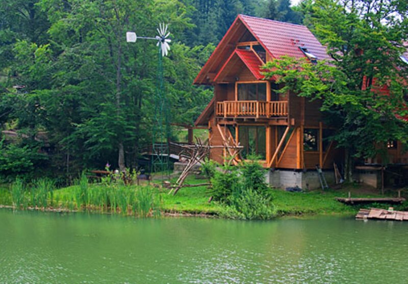 Wooden Cabin by Lake — Green, Serene, Afternoon, Photograph, Windmill
