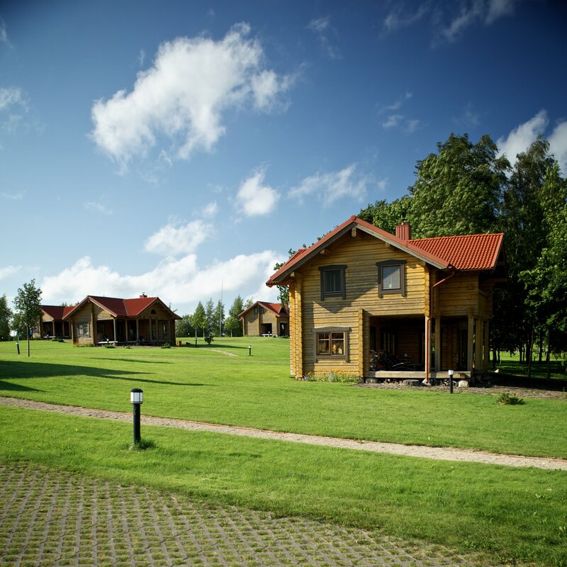 Wooden cabins in a green field