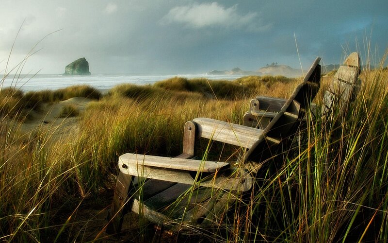 Wooden Chairs on Beach — Green, Serene, Afternoon, Photograph, Grass, Ocean, Rock, Blue