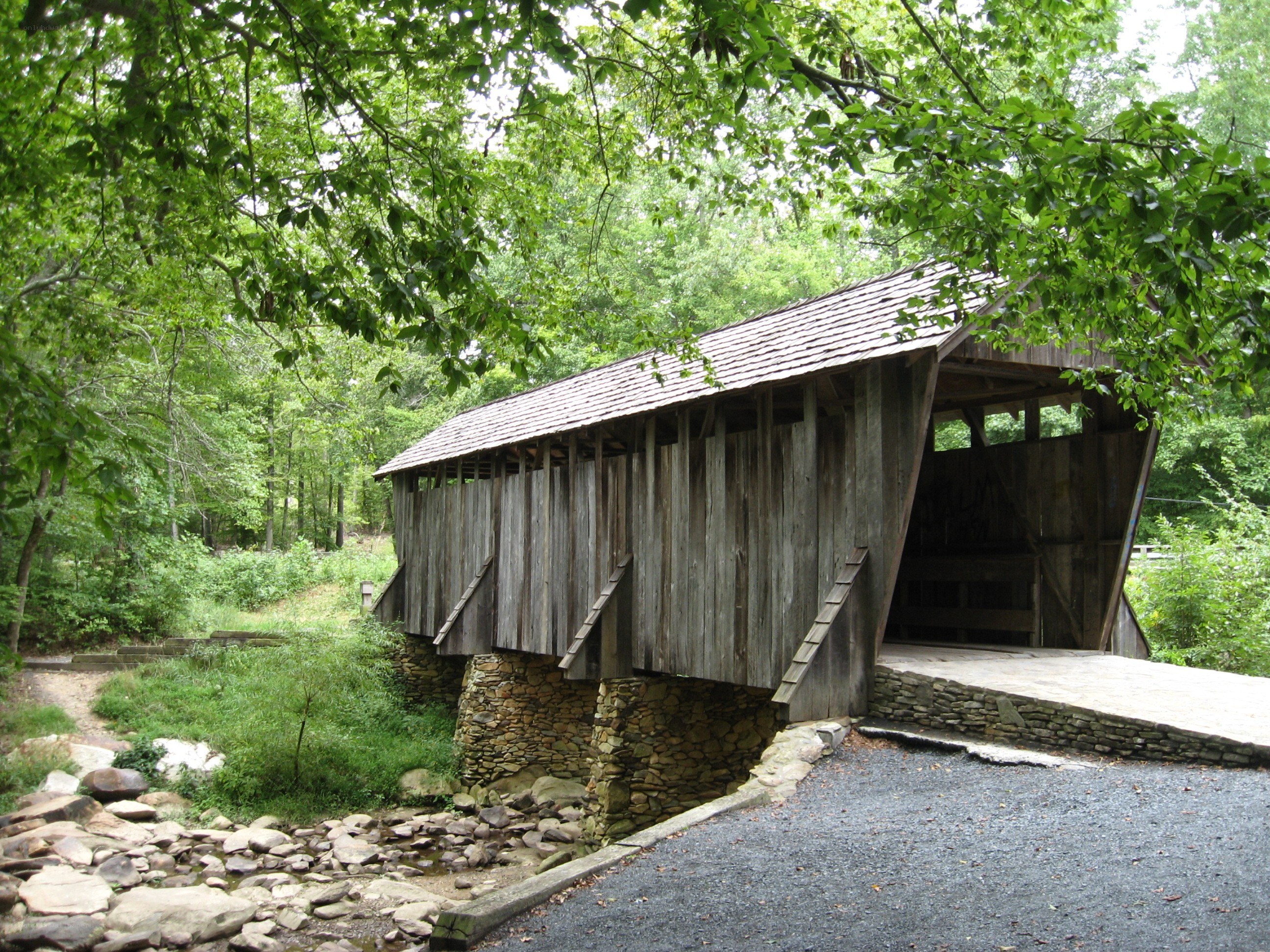 wooden covered bridge in forest