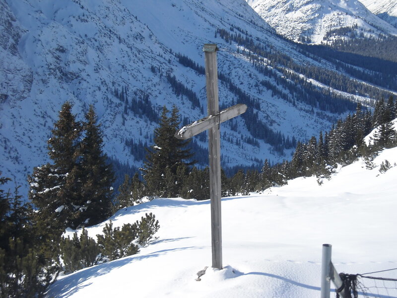 Wooden cross in snowy mountains