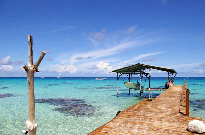 Wooden Dock at Tropical Beach — Blue, Serene, Afternoon, Photograph, Boat, Ocean, Sky