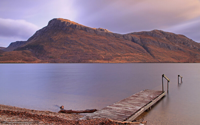 Wooden dock by mountain lake