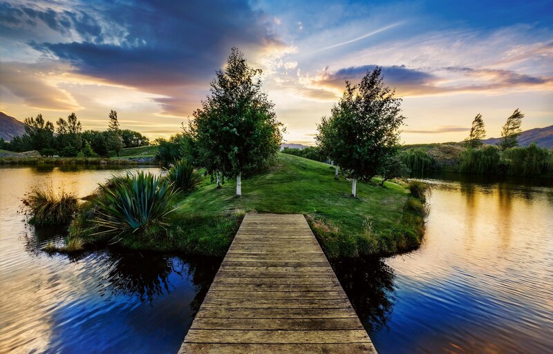 Wooden Dock on Lake — Blue, Serene, Sunset, Photograph, Trees, Grass