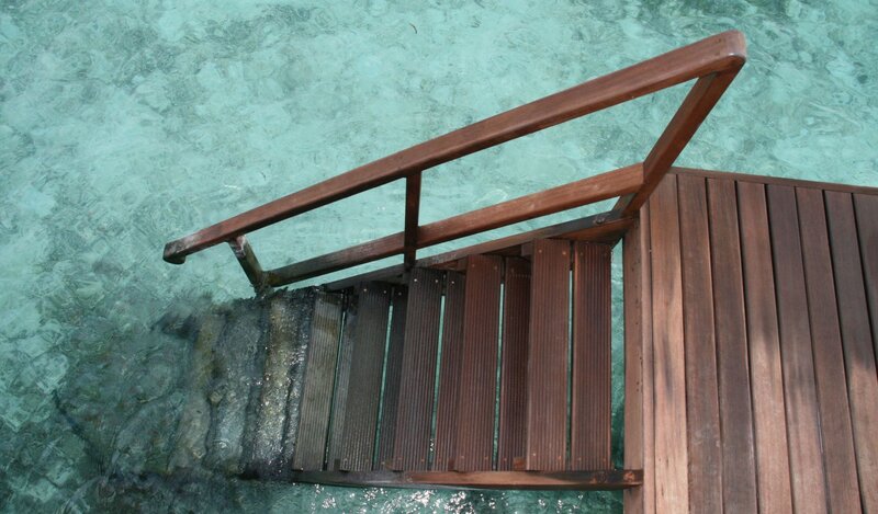 Wooden dock steps in clear water