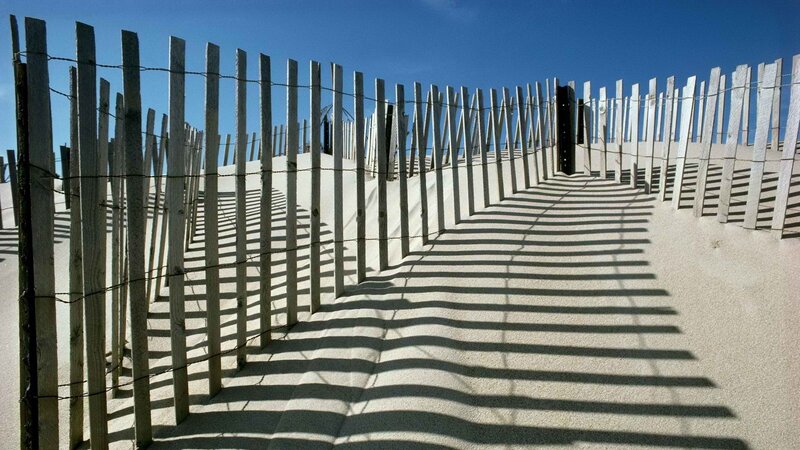 Wooden fence on a sandy dune