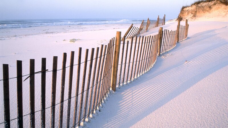 Wooden fence on sandy dune