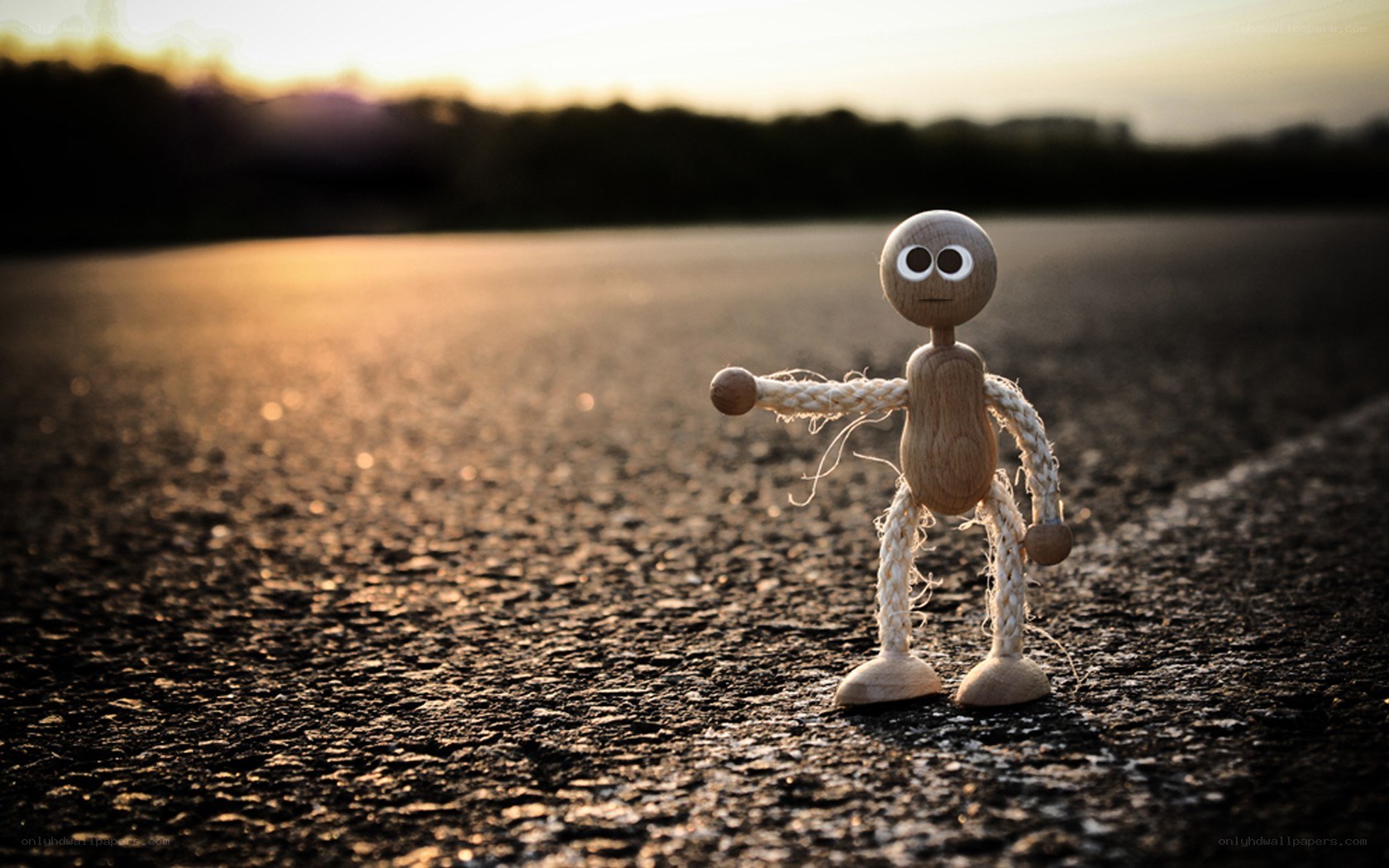 wooden figure on road at sunset