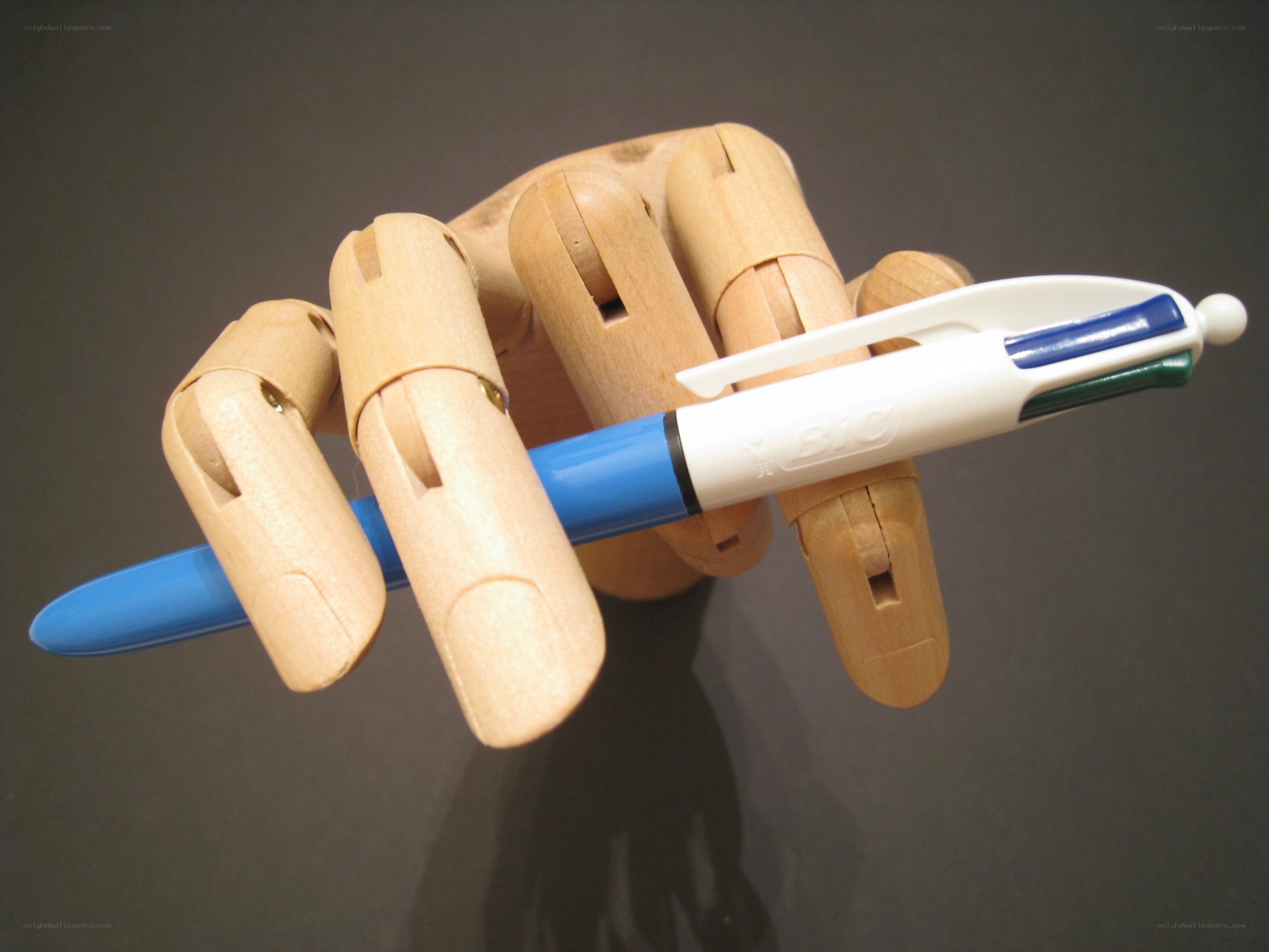 wooden hand holding pen