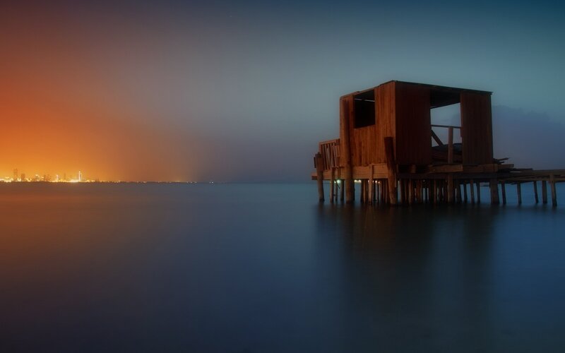 Wooden hut on pier at dusk