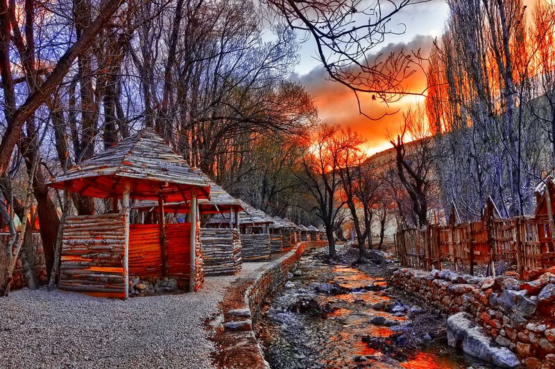 Wooden Huts by Stream