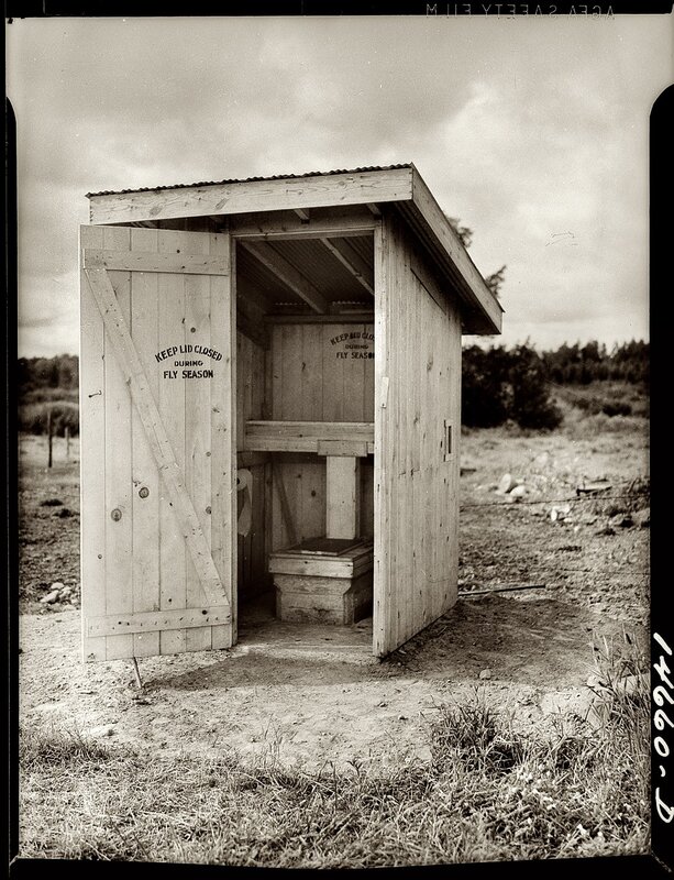 Wooden outhouse in field