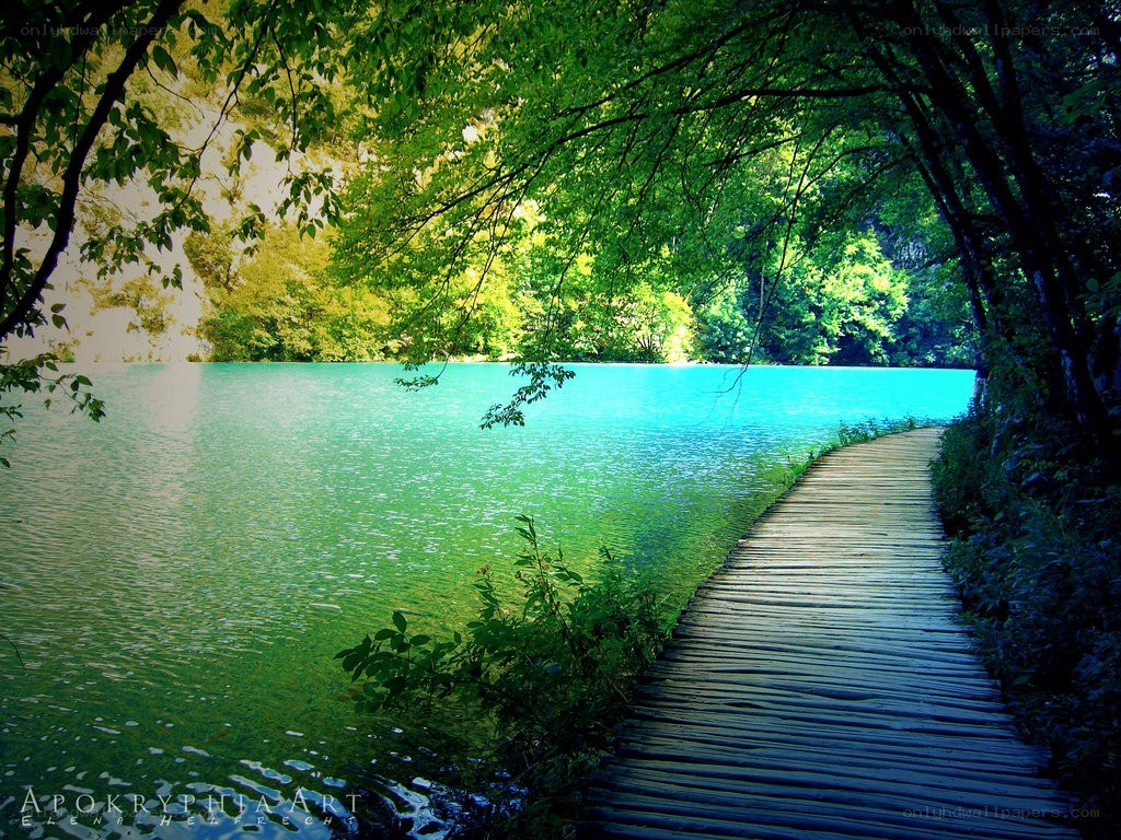 Wooden path by turquoise lake