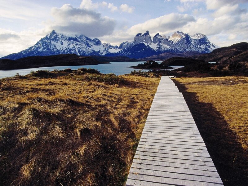 Wooden path to snow-capped mountains