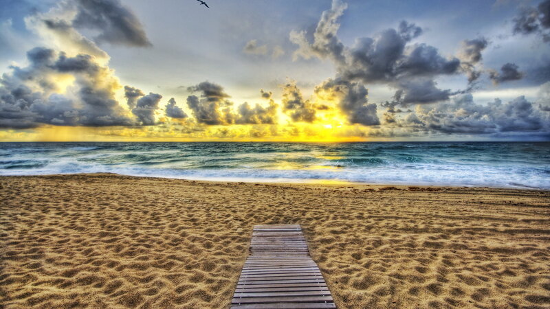 Wooden path to the beach at sunset