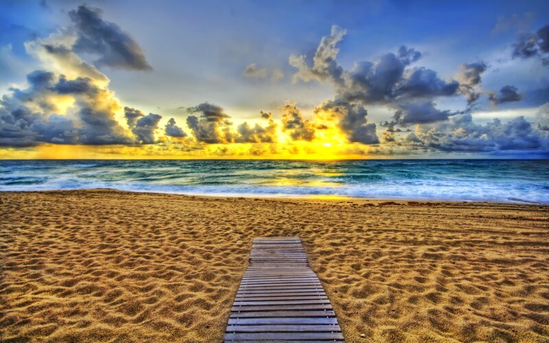 Wooden path to the beach at sunset