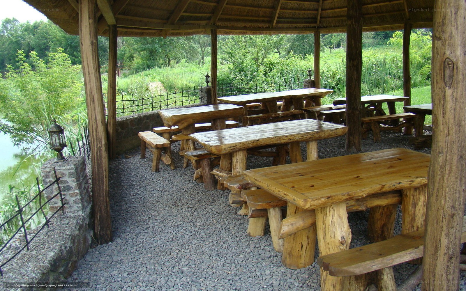 Wooden picnic tables by a pond