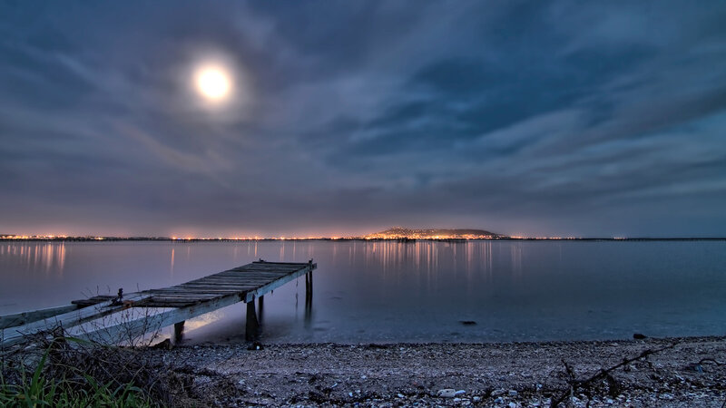 Wooden Pier at Night — Blue, Serene, Photograph, Moon, City Lights