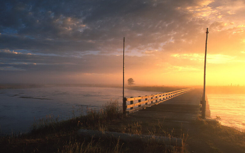 Wooden Pier at Sunrise — Orange, Serene, Photograph, River, Tree, Sky