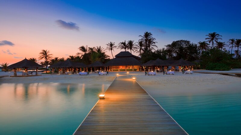 Wooden Pier at Sunset — Blue, Serene, Photograph, Palm Trees, Thatched Huts