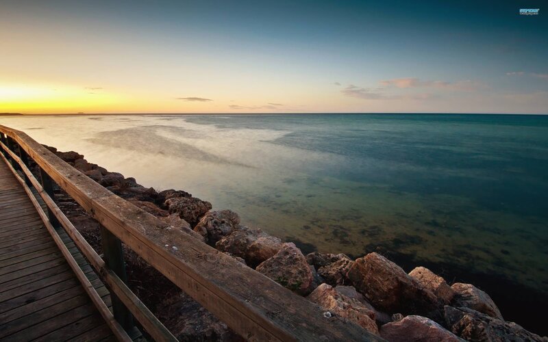 Wooden Pier at Sunset — Blue, Serene, Photograph, Rocks, Ocean, Yellow, Brown, Sky Wallpapers