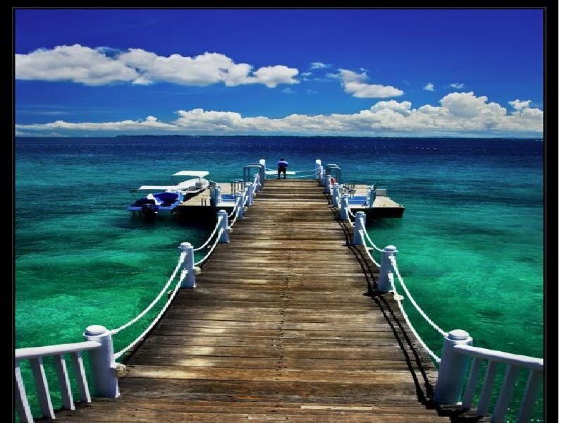 Wooden pier extending into turquoise sea