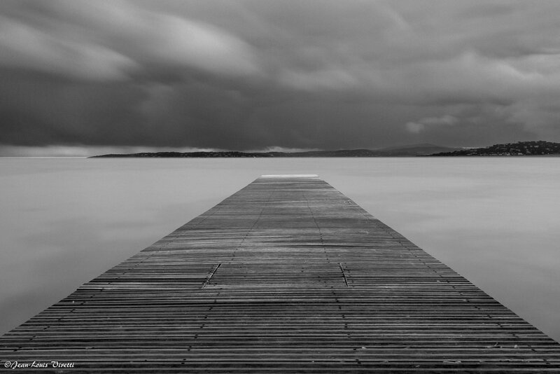 Wooden Pier Extending into Water — Black