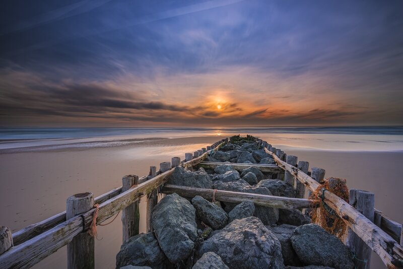 Wooden Pier on Beach — Blue, Serene, Sunset, Photograph, Rocks