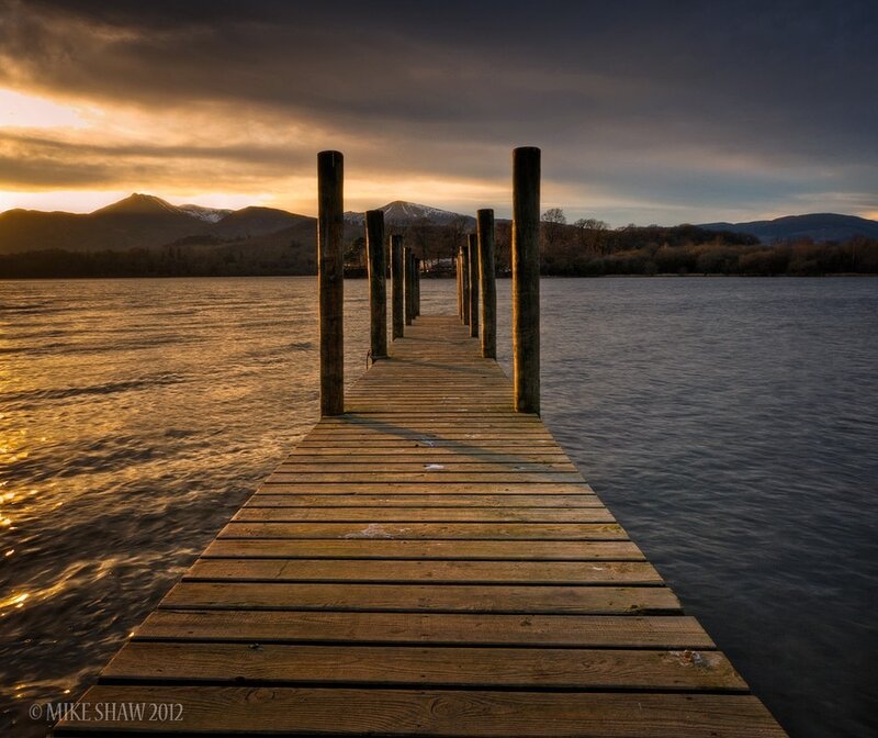 Wooden Pier on Lake — Brown, Serene, Sunset, Photograph, Mountains, Sky