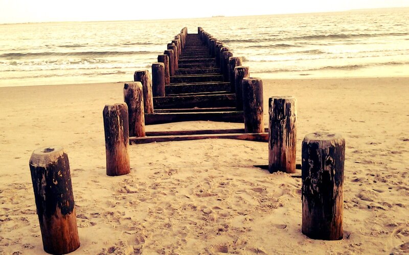 Wooden pier on sandy beach