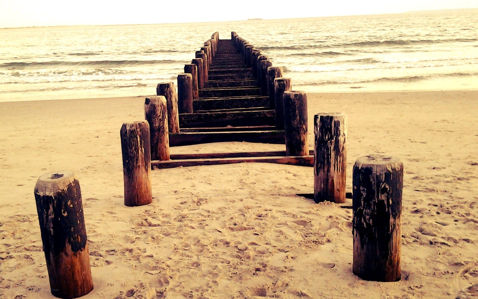 Wooden pier on sandy beach