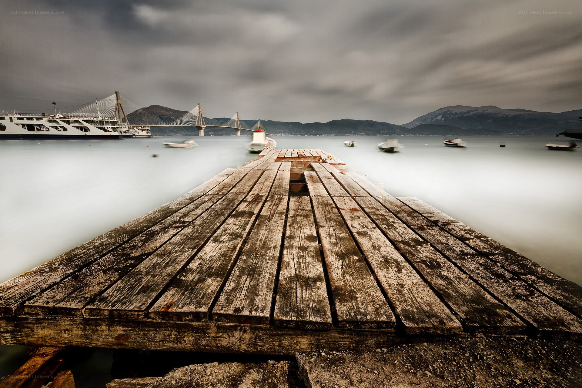 Wooden pier with ferry and bridge