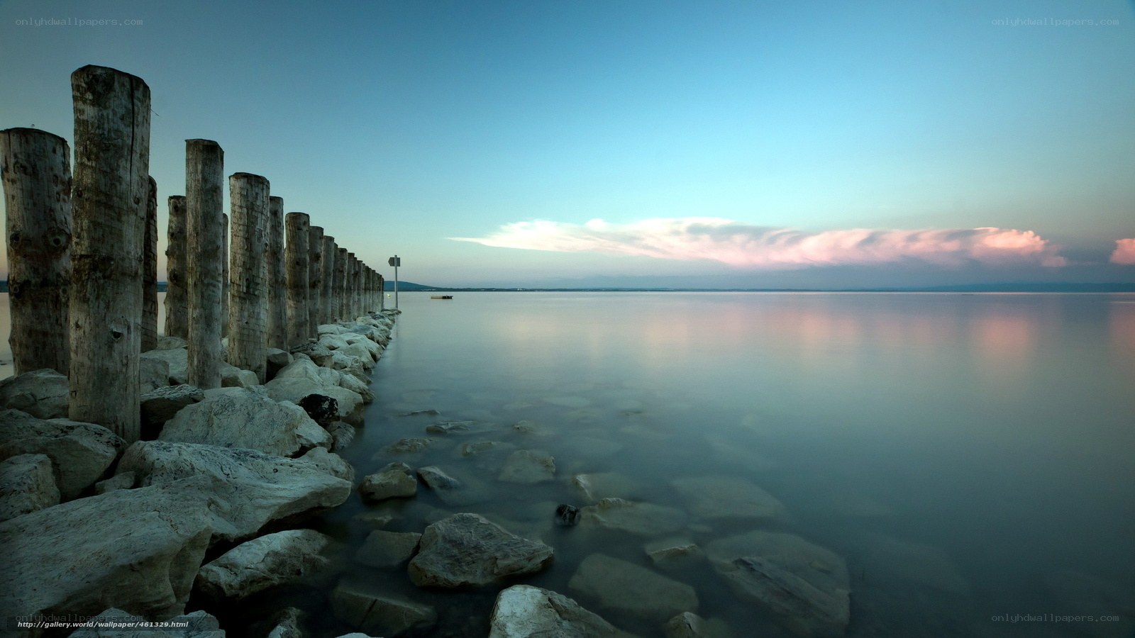 Wooden posts at a calm lake