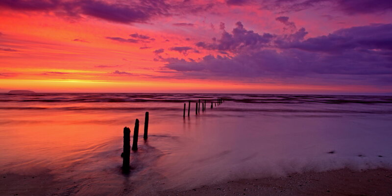 Wooden Posts in Ocean — Purple, Dramatic, Sunset, Photograph