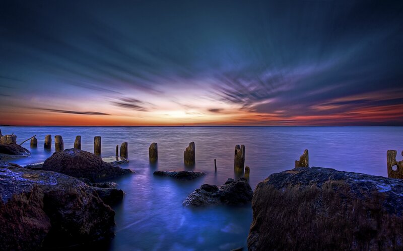 Wooden Posts in Water — Blue, Dramatic, Sunset, Photograph, Rocks, Sky