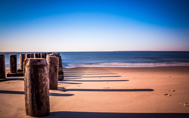 Wooden Posts on Beach — Blue, Serene, Afternoon