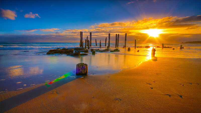 Wooden Posts on Beach — Blue, Serene, Sunset, Photograph, Ocean, Sun
