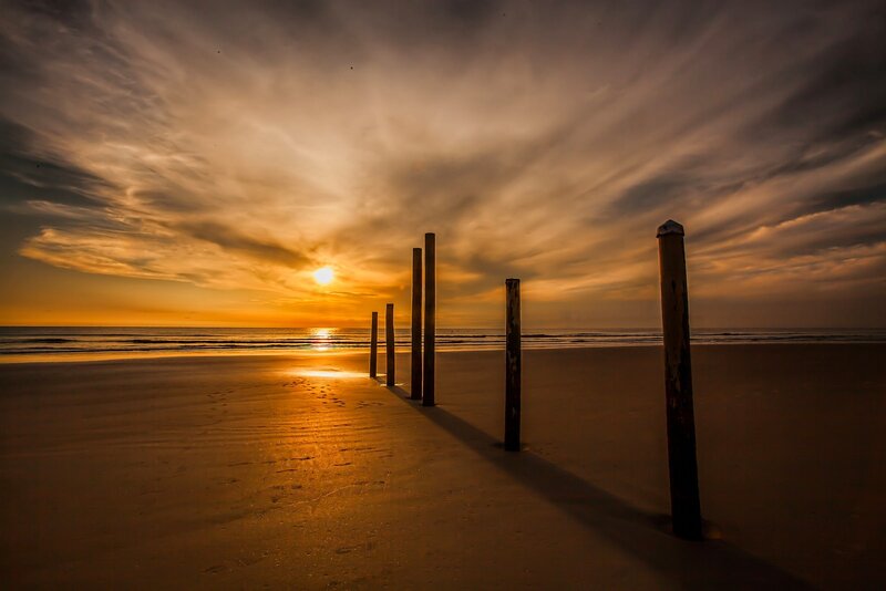 Wooden Posts on Beach — Orange, Dramatic, Sunset, Photograph