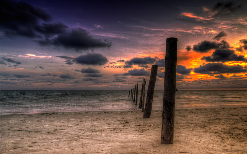 Wooden Posts on Beach — Orange, Dramatic