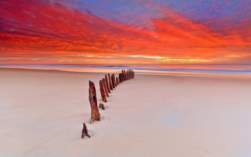 Wooden Posts on Beach — Red