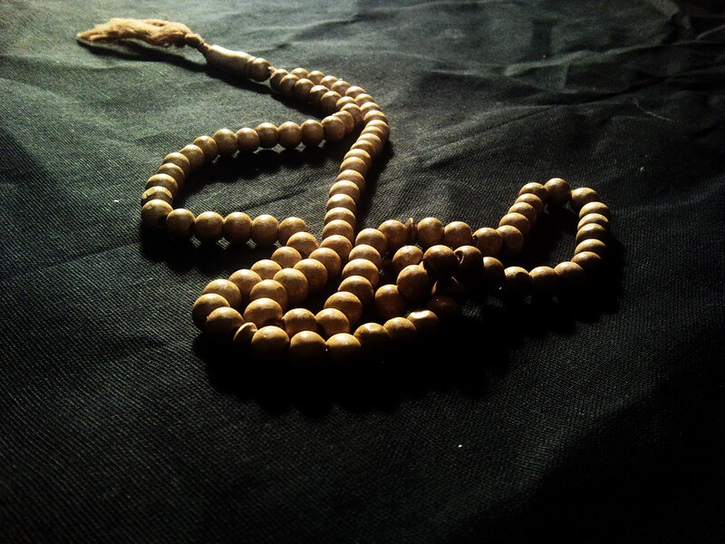 Wooden prayer beads on dark fabric