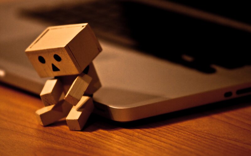 wooden robot figurine on laptop